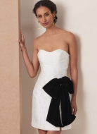 Modell trägt ein kurzes Minikleid mit passendem Cape und dekorativer Schleife genäht nach dem Schnittmuster 2133 von Vogue