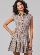 Model is wearing chic shirt dress with half button placket and pleated skirt sewn with the sewing pattern McCalls 8576